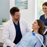 Relaxed dental patient receiving supportive care from a dentist and assistant during a sedation dentistry appointment.